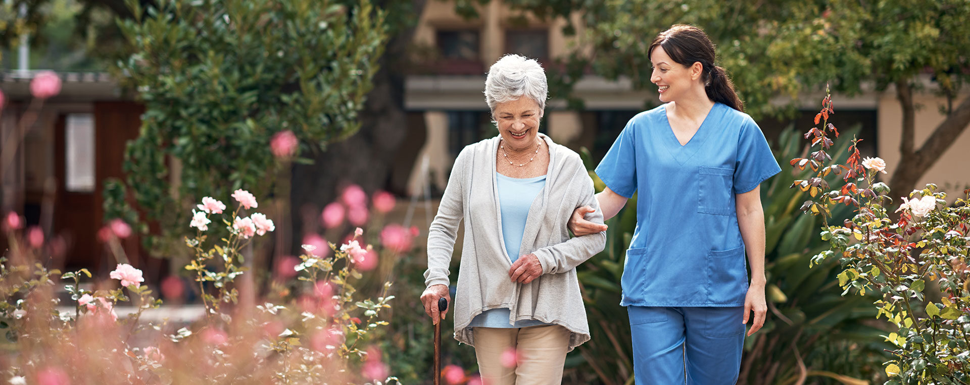 caregiver walking elderly through garden